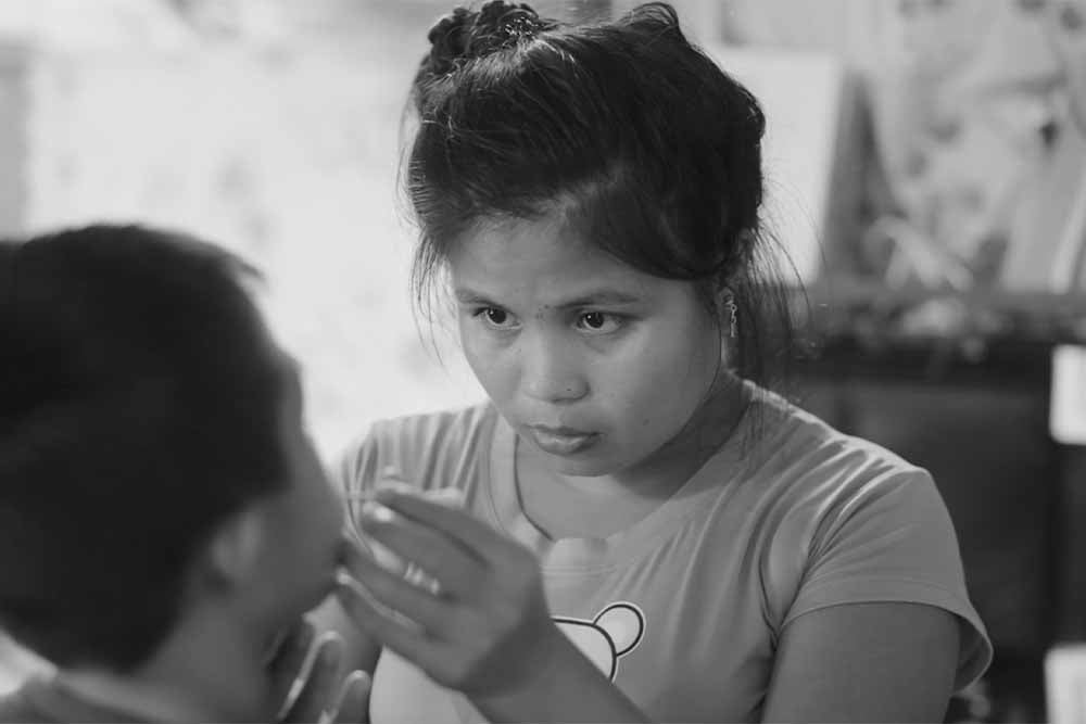 Jessa giving medicine to her brother Jary after his cleft surgery