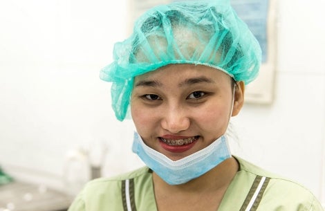 Gracee smiling in nurse scrubs