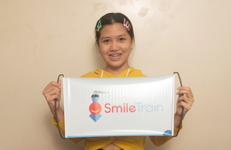 Teen holds Smile Train banner 