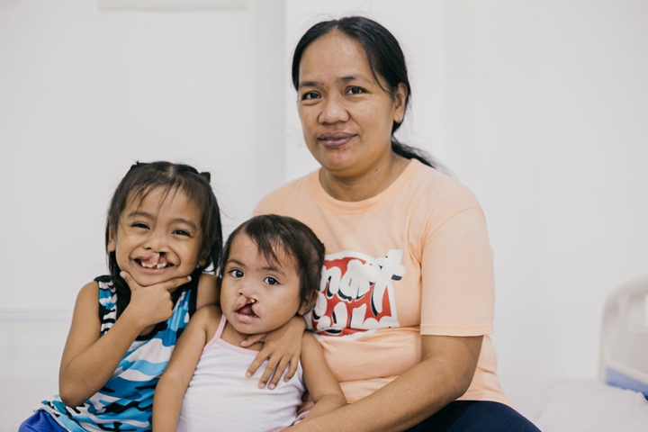 Maricel Pacatang smiling with her daughters Ernie Jr. and Ermalen before their cleft surgeries